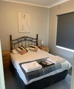 a bedroom with a bed with a large window at Hello Adelaide Motel and Apartments in Adelaide