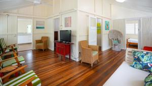 a living room with a couch and a television at Daggoombah Holiday Home Magnetic Island in Arcadia