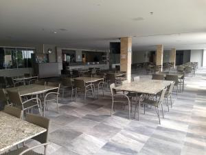Un comedor con mesas y sillas en un restaurante. en PARK VEREDAS FLAT SERVICE, en Rio Quente