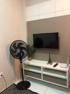 een woonkamer met een ventilator voor een televisie bij apartamento 04 super luxo, com garagem, vila-alta Crato in Crato