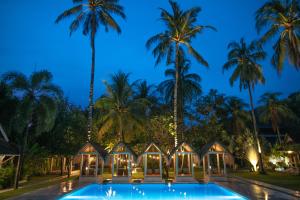 a villa with a swimming pool at night at The Forty Eight Resort Candidasa in Candidasa