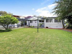 a house with a yard with a grassy yard at Gone Fishing in Culburra Beach