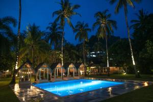 a villa with a swimming pool at night at The Forty Eight Resort Candidasa in Candidasa