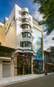 a tall white building on the side of a street at Midori Boutique Hotel in Hanoi