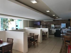a restaurant with a bar and tables and chairs at Lindo apto em Arraial do Cabo condomínio Golden Lake in Arraial do Cabo