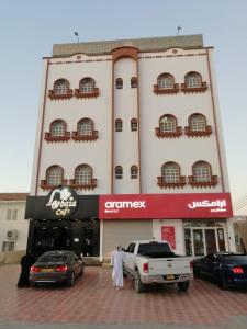 a white truck parked in front of a building at Five Continents Hotel in Sur