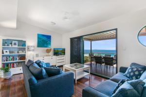 un salon avec deux canapés bleus et un balcon dans l'établissement Lookout Unit 8, à Point Lookout