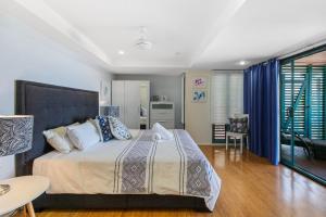 une chambre avec un grand lit avec des rideaux bleus dans l'établissement Lookout Unit 8, à Point Lookout 11 autres photos