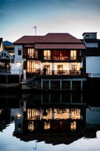 a house on a dock next to a body of water at Punyashthiti villa in Chanthaburi