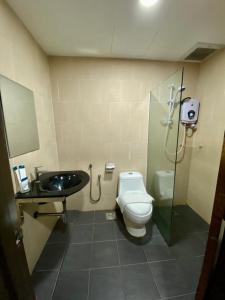 a bathroom with a shower and a toilet and a sink at Summit Signature Hotel Batu Pahat in Batu Pahat