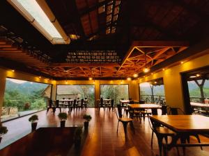 a restaurant with tables and chairs and large windows at The Wild Trails Munnar Resort in Munnar