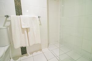a bathroom with a white towel hanging on the wall at Absolute Beachfront Opal Cove Resort in Coffs Harbour
