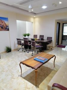 una sala de conferencias con mesa y sillas en درة الخوير للشقق الفندقيه en Mascate