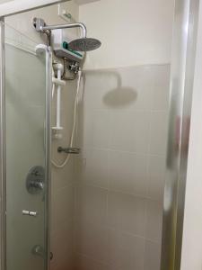 um chuveiro numa casa de banho com uma porta de vidro em Wind Residences Tagaytay em Tagaytay