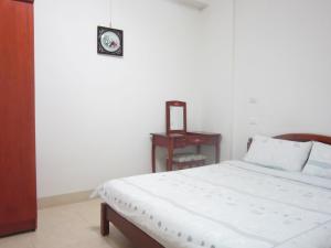a bedroom with a bed and a table with a mirror at Travelers Fu-Home in Hualien City