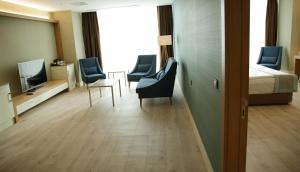 a hospital room with a bed and chairs and a tv at The Ankara Hotel in Ankara