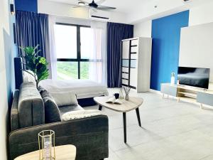 a living room with a couch and a bed at Bell Suites Moka in Sepang