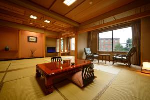 sala de estar con mesa de madera y sillas en Hotel Daiheigen, en Otofuke