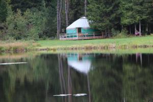 um gazebo sentado ao lado de um lago em Yurtos em Gaugariai