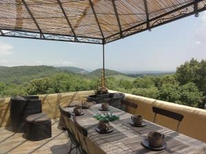 a table with chairs and a view of the mountains at Domaine de la Borie in Trans-en-Provence