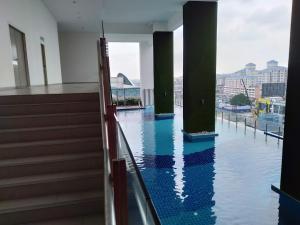 een zwembad met water in een gebouw met zuilen bij #4 Summer Studio - One South in Seri Kembangan