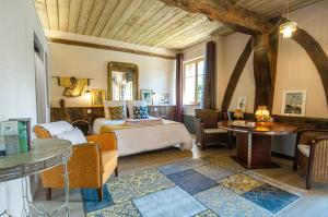 a bedroom with a bed and a table and chairs at Domaine du Lieu des Brocs - Country Club in Brucourt