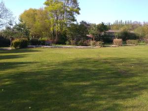 un gran campo de hierba con una gran sombra. en Domaine du Lieu des Brocs - Country Club, en Brucourt