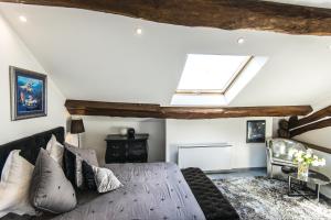 a living room with a bed and a skylight at Le Petit Domaine de Bois Avril in Étais-la-Sauvin