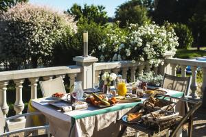 einen Tisch mit Tellern aus Essen auf einem Balkon in der Unterkunft Le Petit Domaine de Bois Avril in Étais-la-Sauvin