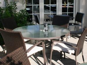Storia Da Ennio في La Verrière: طاولة زجاجية وكراسي على الفناء