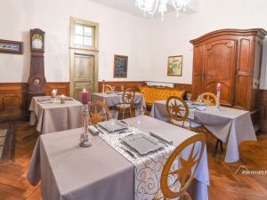 uma sala de jantar com mesas e cadeiras e um relógio em Le Château d'Orleix em Orleix