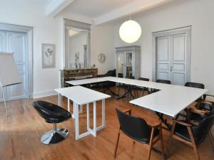 una sala de estar con mesas y sillas blancas. en Le Château d'Orleix, en Orleix