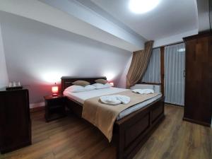 a bedroom with a bed with two towels on it at Cabana Rares in Ranca