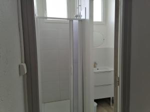 a white bathroom with a sink and a window at Centre de vacances La Salamandre in Arrens-Marsous