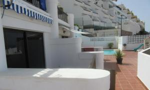 a white apartment building with a swimming pool at Vista Playa in Mogán