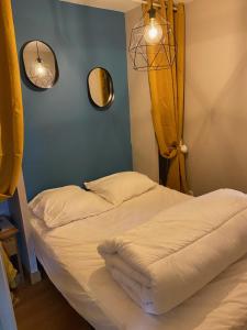 1 dormitorio con 2 camas y 2 espejos en la pared en appartement au pied des pistes en La Chal