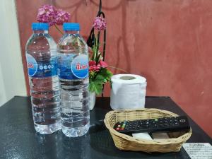 シーラーチャーにあるLek Homestayのボトル入り飲料水2本、テーブルのリモコン