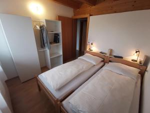two beds in a small room with two lamps at Ferienwohnung Ela in Reutte