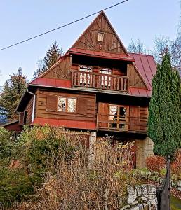 ein großes Holzhaus mit rotem Dach in der Unterkunft Sępia Chata Dom Do Wynajęcia in Świeradów-Zdrój