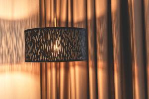 ein schwarzes hängendes Licht, das an einer Metallwand hängt in der Unterkunft PLAZA Premium Parkhotel Norderstedt in Norderstedt