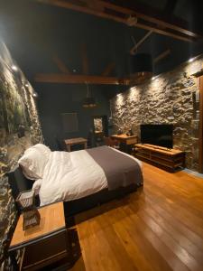 a bedroom with a bed and a stone wall at La LAITERIE Ecaussinnes in Les Croisettes