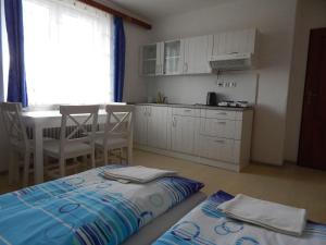 a room with a kitchen and a table with a bed at Privat Severka in Pavčina Lehota