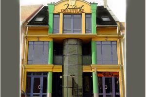 a yellow and green building with a sign on it at Romantic Studio Apartment in the heart of the city in Komárom