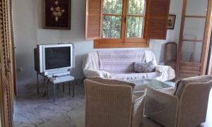 - un salon avec une télévision, un canapé et des chaises dans l'établissement CASA-B- pequeño conjunto adosados, à La Caleta-Guardia
