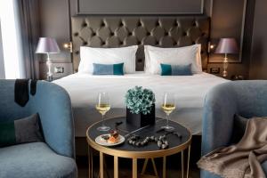 a hotel room with a bed and a table with wine glasses at Hotel La Place Roma in Rome