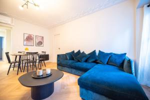 a living room with a blue couch and a table at Luxury apartments in Paris Center in Paris