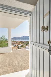 an open door to a patio with a view of the ocean at The Windmill Kimolos in Kimolos