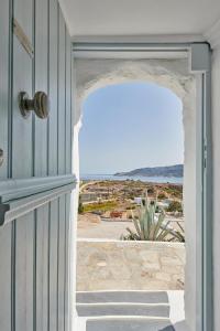 an open door with a view of the ocean at The Windmill Kimolos in Kimolos