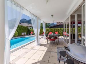 a patio with a pool and a table and chairs at Landhaus Central in Söll