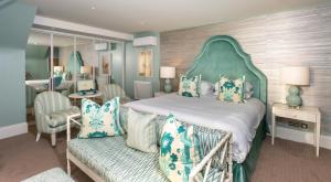 a bedroom with a large bed with a green headboard at Roslin Beach Hotel in Southend-on-Sea